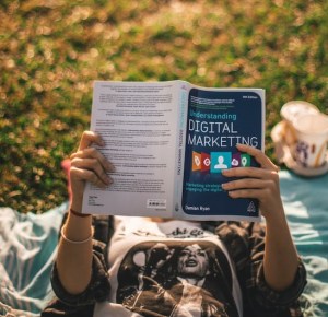 Person reading digital marketing book.